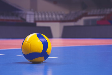 Volleyball ball on blurred wooden parquet background. Banner, space for text, close up view with...