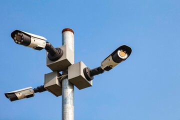 Three CCTV cameras on a tall pole at the park