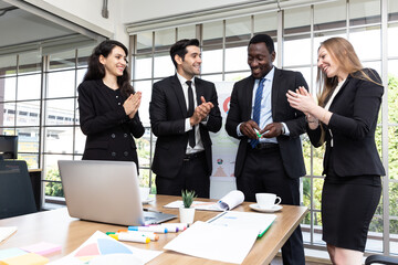The multi-ethnic marketing team in the black suit was delighted with the first quarter sales hitting their target.