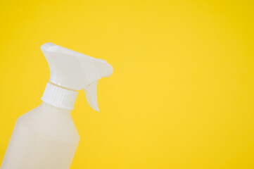 Closeup shot of a white plastic spray bottle isolated on yellow background
