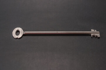 A safe key, safe key in an extra long design. The background is black and there is plenty of space for text.Ein Tresorschlüssel, Safe-Schlüssel in einer überlangen Ausführung