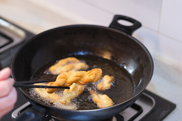 close up hand making deep-fried dough twist. Traditional Chinese snack