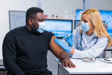Professional doctor makes a coronavirus vaccine using a syringe and hypodermic needle. Professional...