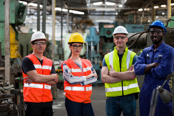Confident diversity factory worker in factory. Male and female worker wearing safety uniform, helmet at work factory. Group of worker working at factory