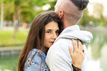 Obraz premium couple in love hugging at sunset and looking at each other