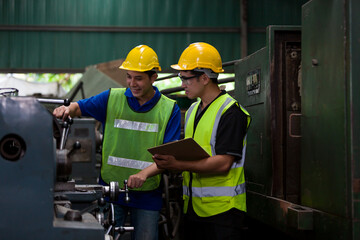 Asian male worker working with lathe machine in the factory. Male engineer worker checking, repair...