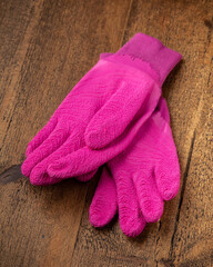 Fototapeta na wymiar New Pink Purple Gardening Gloves on wooden background gardening concept