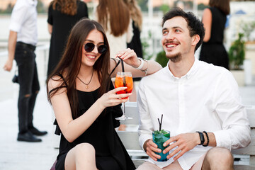 couple seating on the beach bar and drink cocktails. couple drink cocktails