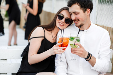 couple seating on the beach bar and drink cocktails. couple drink cocktails