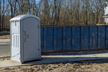 Portable restroom on house under construction in a dumpsters construction with garbage new house