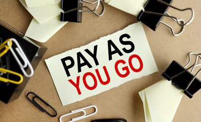 Pay As You Go . text on a yellow sticker on the table near the stationery clips.