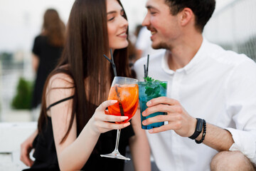 couple seating on the beach bar and drink cocktails. couple drink cocktails