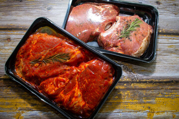pieces of meat in packing on a wooden background