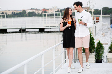 couple seating on the beach bar and drink cocktails. couple drink cocktails