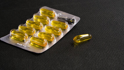 Cod liver oil omega 3 capsules on the black background