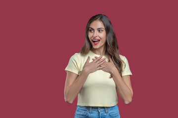Surprised woman holding hands to her chest