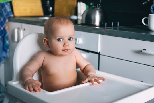 Baby girl is sitting in a highchair
