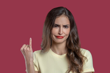 Woman with regretful grimace showing her pinky