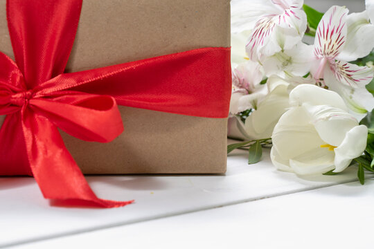 composition of a gift box, and a bouquet of flowers. holiday and congratulations concept