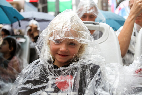 girl wearing poncho on sightseeing bus in times square new york city