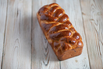 Loaf of homemade wicker white bread on a wooden background, close-up.