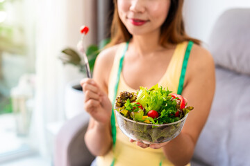 Young woman eating homemade healthy salad at home, Healthy eating lifestyle and diet concept