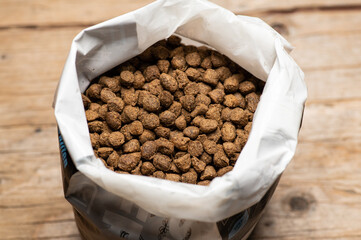dry nutritious food in granules in a packaging bag on a wooden background