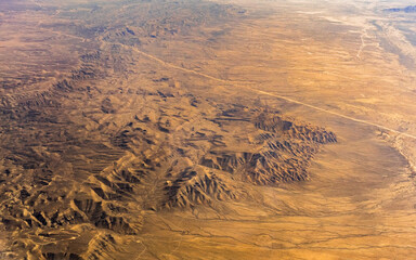 Airplane perspective of Airzona, Texas desert landscape. Endless roads over sandy mountains.