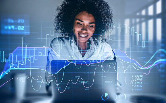 Attractive smiling African American business woman or stock trader analyzing stock graph chart using laptop, Portrait front view businesswoman. 