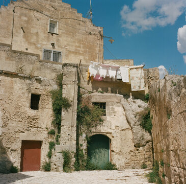 clothes hanging on a line outwide of very old stone buildings in italy