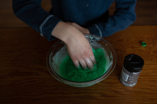 Tween boy mixing slime with his hands