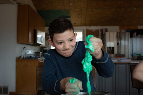 Boy squeezing the slime he made at home