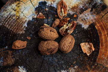 brown walnuts lie on an old rotten stump top view