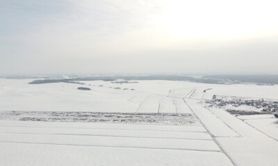 Top view of rural landscape with snow covered field in winter