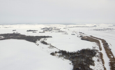 Top view of rural landscape with snow covered field in winter