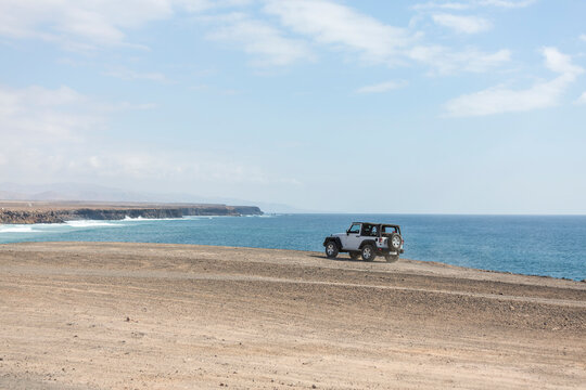 White Jeep 4x4 Driving On A Oceanic Cliff With Ocean In The Background