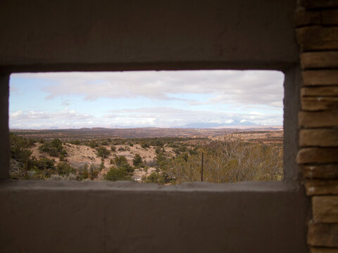Rectangular window frames a sparse desert landscape.