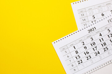 On a yellow background, two calendars of 2021. Top view with copy space