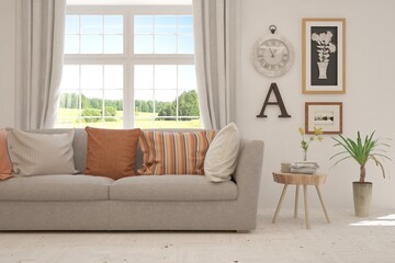 Fototapeta premium White living room with sofa and summer landscape in window. Scandinavian interior design. 3D illustration