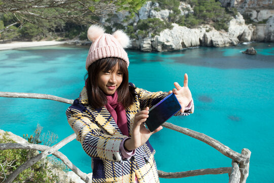Chinese young woman taking selfie at viewpoint