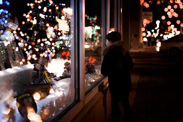 Small Young Boy Looking At Christmas Decorations Inside A Store Window