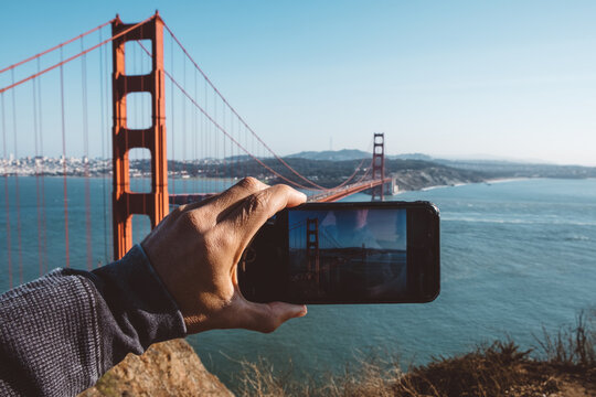 Tourist taking a photo of the Golden Gate Bridge in San Francisco