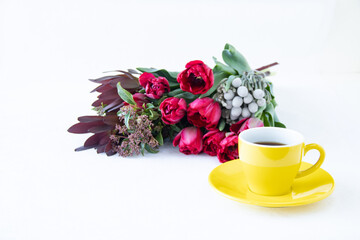 シルバーブルニアとリューカデンドロンとガマズミと赤いチューリップの花束とコーヒー