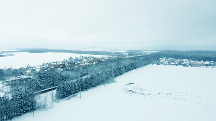 Fototapeta na wymiar Aerial view from drone on blue snowy suburb in winter