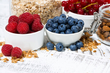 fresh blueberries, raspberries and breakfast products on white table