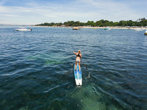 Young woman on stand up paddling board
