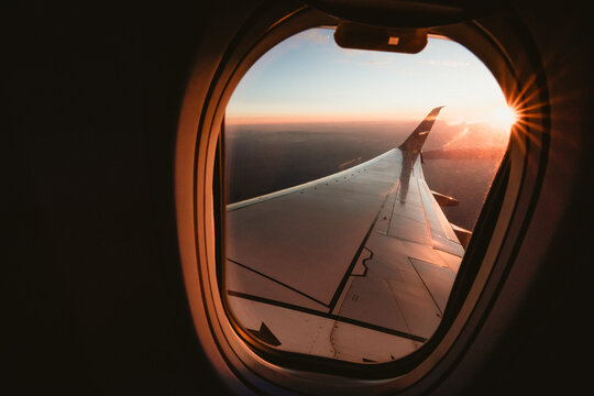 Sunset over California from the window seat of a plane with a sun star
