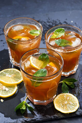 iced tea with mint and lemon on dark background, top view vertical
