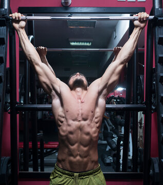 Man working out doing chin ups in the gym