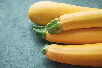 Four yellow zucchini on kitchen table. Whole raw courgettes